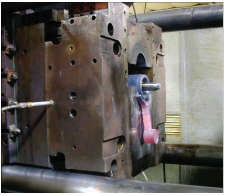 Fig. 7 – Die cast copper rotor about to be ejected from the center platen portion of the 750 ton machine.