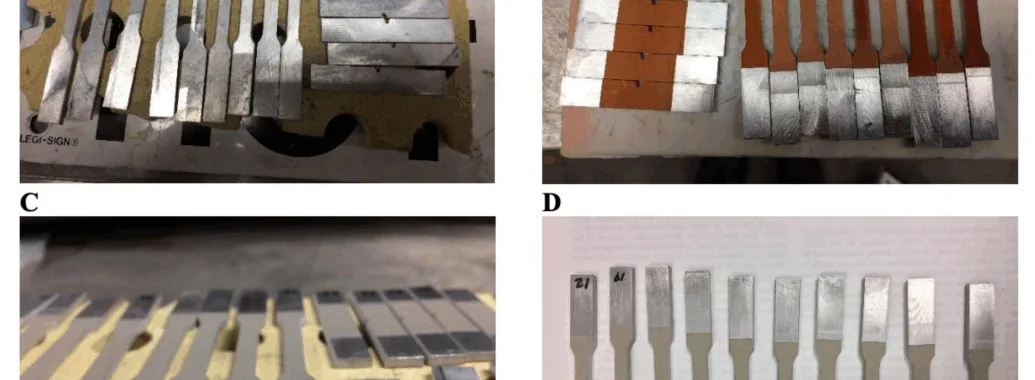 Figure 1. (A) Digital image of the waterjet cut HPDC A365 substrate/base material as reference specimens that therefore did not undergo cold gas dynamic spray (CGDS) processing. (B) Digital photo of the thinly coated and Cu CGDS processed A365 HPDC substrate specimens. (C,D) Digital images are similar to (B), where Ni and Ti were utilized as feedstock, respectively. For reference, the thickness of the base material (see (C) with the properly oriented specimen labeled “30”) was 2.5 mm before CGDS processing or postprocessing after that. Solution treatments we